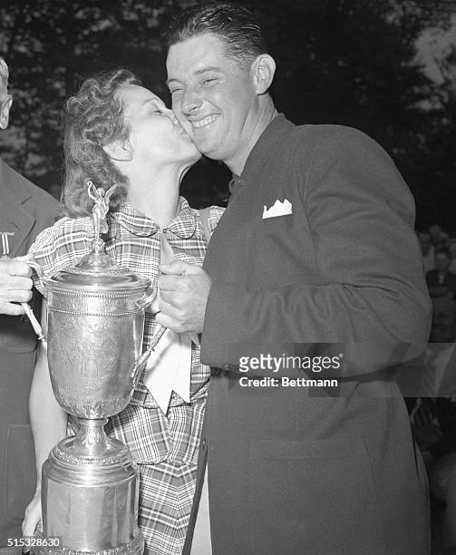 Mrs. Edith Middlecoff plants a big kiss on the cheek of her husban, Dr. Cary Middlecoff, the Memphis dentist after he was presented the National open...