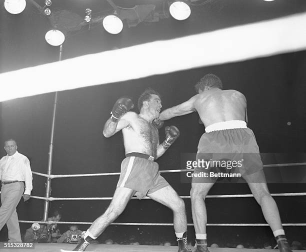 Marcel Cerdan is rocked back by a left to the shoulder from Jake LaMotta, during their middleweight title bout in Detroit, June 16. LaMotta won by a...