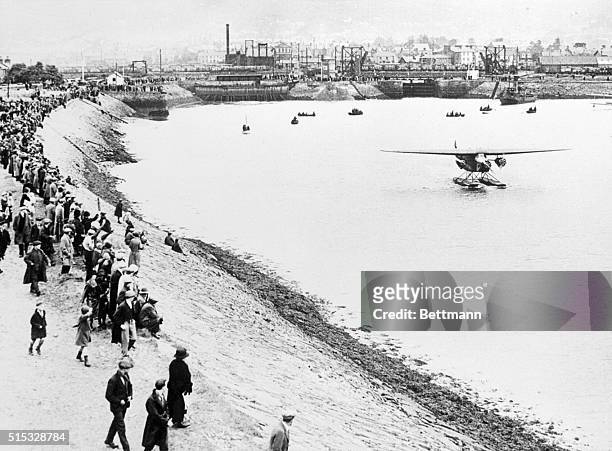 The crowd at Burry Port, a small Welch mining town, gather around to watch the seaplane Friendship, containing Amelia Earhart and crew, taxi out of...