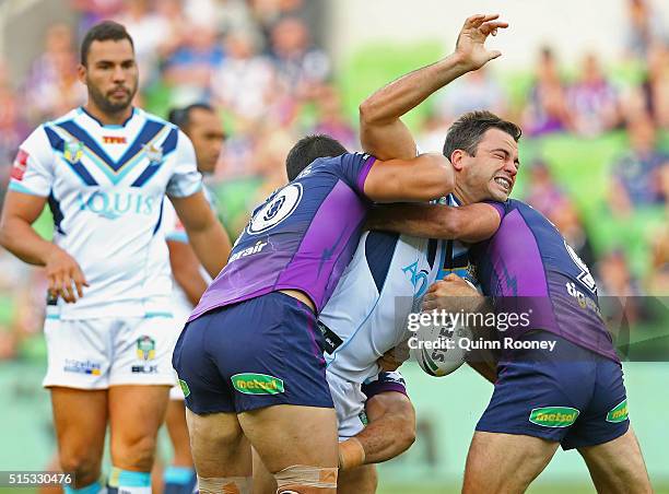 David Shillington of the Titans is tackled by Jordan McLean and Cameron Smith of the Storm during the round two NRL match between the Melbourne Storm...