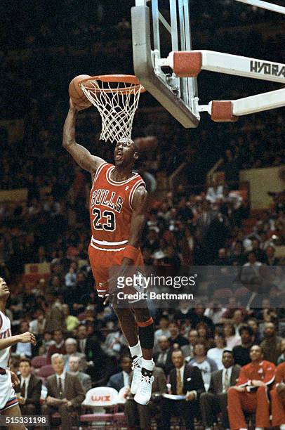 Chicago Bulls' Michael Jordan stuffs the basketball through the basket as the Knicks' Maurice Cheeks watches helplessly as Madison Square Garden 2/14.