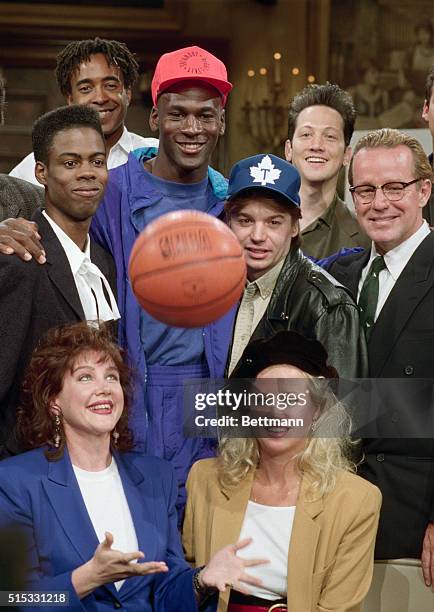 The Chicago Bulls' Michael Jordan, center, learns that he will host the season premiere of Saturday Night Live. Surrounding Jordan, clockwise from...