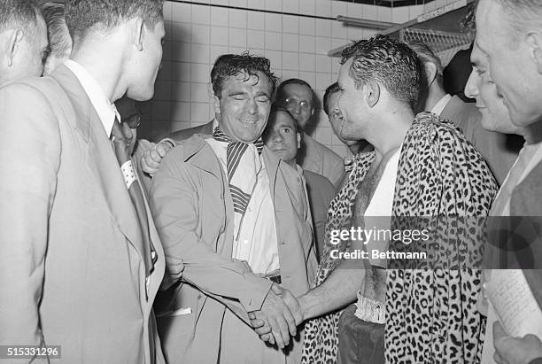 Marcel Cerdan congratulates the new middle weight champion, Jake LaMotta. Jake has on the leopard-skin coat that he wore into the ring as a robe on...