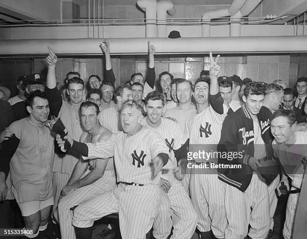 Wild-eyed Casey Stengel , manager of the Yankees, leads his players in a cheer in the Yankee Stadium dressing room after the club beat the Boston Red...