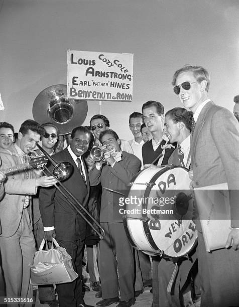 The Roman counterpart of the "New Orleans Jazz band" is on hand to greet visiting American trumpeter Louis Armstrong with large welcoming signs. The...