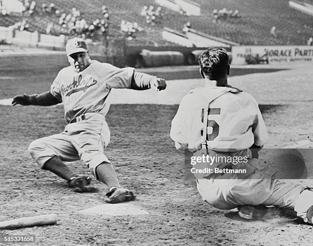 Boston: Dolf Cammilli Dodgers first baseman, slides into home plate with one of his team's five runs that were put across in the 5th inning against...