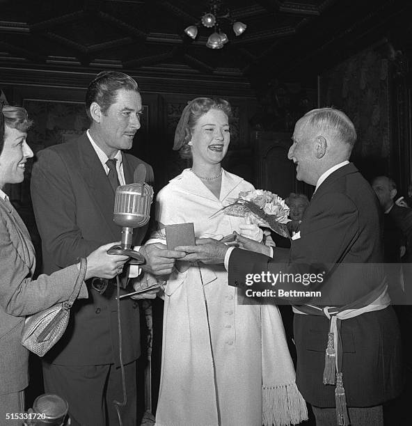 Flynning a Bride. Monte Carlo: Film actor Errol Flynn and his 22-year-old actress bride Patrice Wymore, get a wedding souvenir from Mayor Charles...