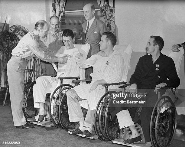 Major General Milliard F. Harmon, Chief of the Air Staff of the Army Air Forces, decorates wounded flyers at Walter Reed General Hospital in...