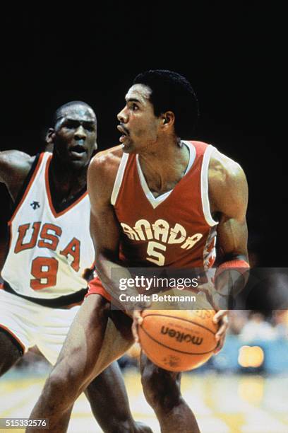 Michael Jordan guards Canada's Tony Simms in the semifinals of men's basketball at the Forum. USA won 78-59.