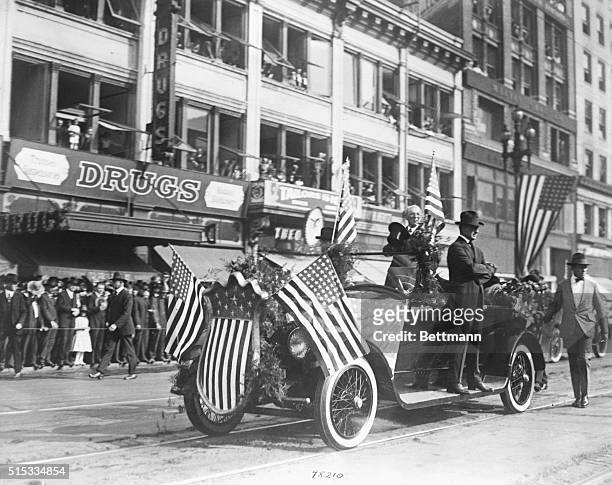 San Francisco, CA: A Secret Service agent rides on the running board of President Woodrow Wilson's automobile, as President Wilson waves his hat...