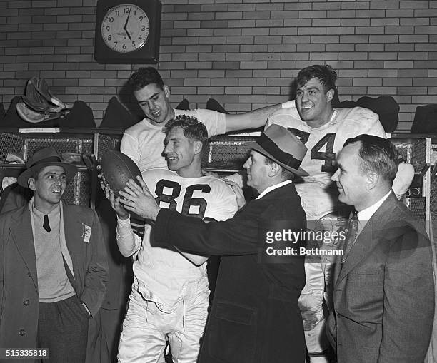 Dub Jones admires football handed to him by Cleveland Browns' coach Paul Brown, in dressing room after the Browns defeated the Chicago Bears 42-21....