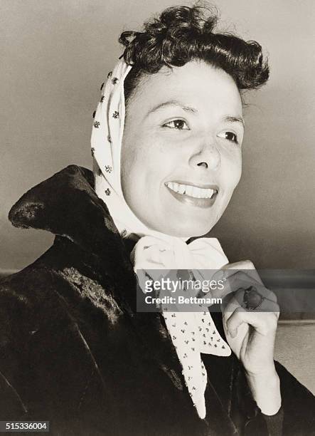 Southamptton, England: Dynamic Lena Horne arranges her scarf as she arrives in Southampton aboard the Ile de France from New York. Headed for Paris...