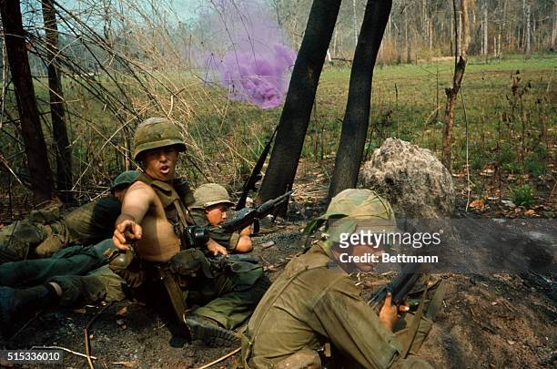 American soldier turns to give instructions as firing continues in front of him during Operation Byrd in the Vietnam War.