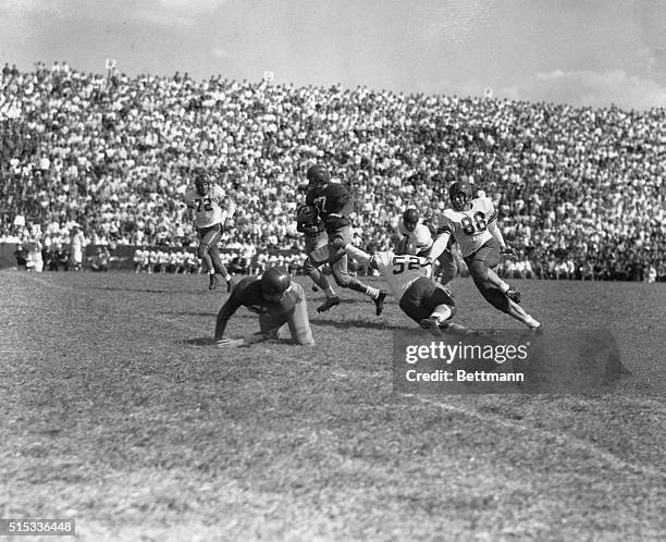 Doak Walker, No. 37, the fleet footed All-American running back of Southern Methodist University, glides safely past a handful of Texas Tech players...