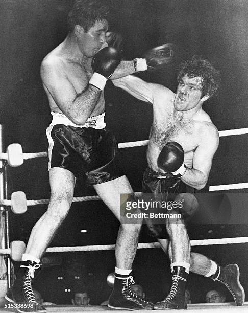 Cleveland's Joey Maxim wards off the right arm of Britain's Freddie Mills during their light heavyweight title fight at Earl's Court. Maxim knocked...