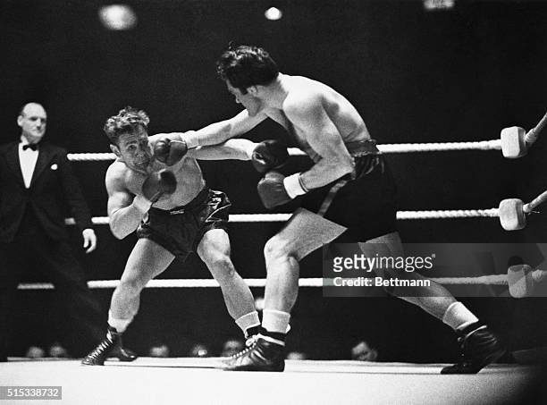 Gus Lesnevich, Cliffside, N.J., world's light heavyweight champion, takes a hard right from Freddie Mills of England during their scheduled 15-round...
