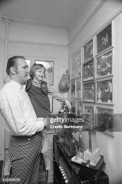 Heavyweight Chuck Wepner shows him daughter, Kim 3, trophies, photographs and other mementoes of his ring career as they relax at their Bay Bayonne...