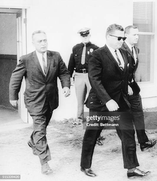 Gary Thomas Rowe , is flanked by FBI agents as he leaves court here on October 21, after giving testimony in the retrial of Ku Klux Klansman collie...