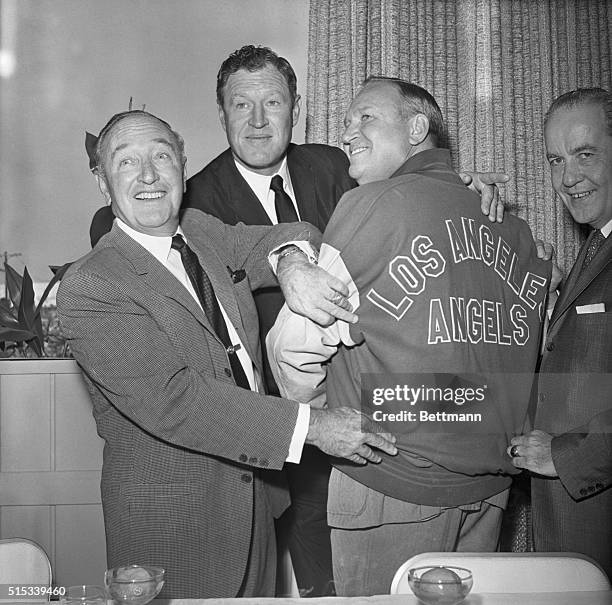 Fred Haney who was named General Manager of the new American League Los Angeles Angels, checks the warm-up jacket worn by Angels' Board Chairman,...