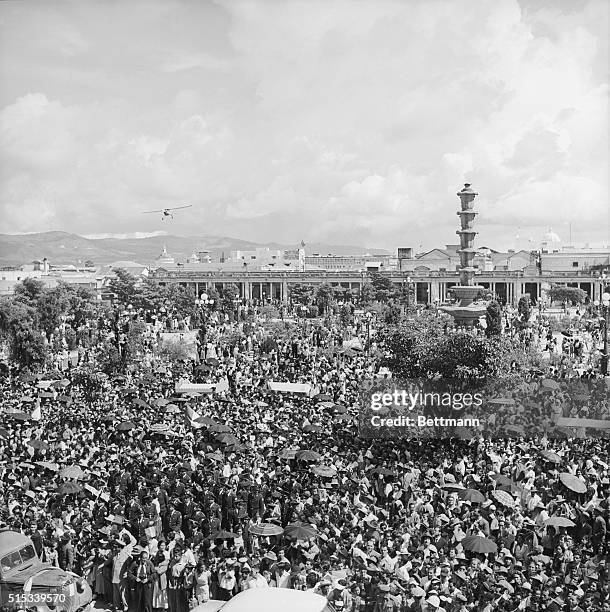 While thousands of people crowd the plaza in front of the National Palace in Guatemala City, a low flying plane drops leaflets welcoming the new...