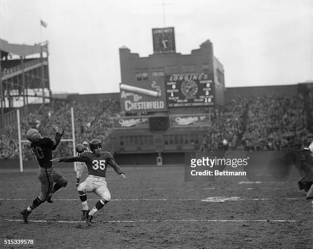 Looking like a pair of acrobatic jugglers, Jack Butler , Pittsburgh end, leaps high for the pigskin in a vain attempt at snaring a pass while Giants'...