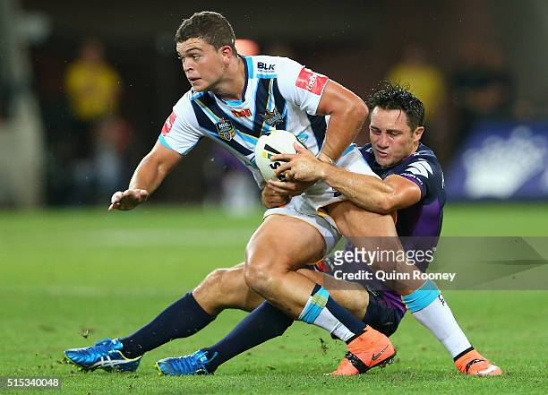 Ashley Taylor of the Titans is tackled by Cooper Cronk of the Storm during the round two NRL match between the Melbourne Storm and the Gold Coast...