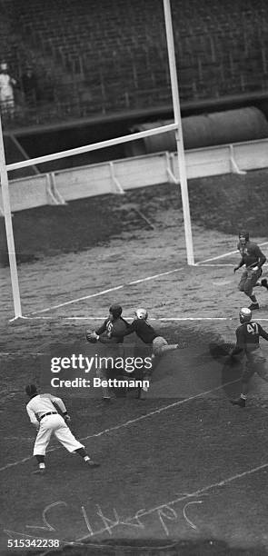 With a Fordham tackler frantically clinging to him, left end Herb Maffet, of the University of Georgia enters the end zone with the pigskin clutched...