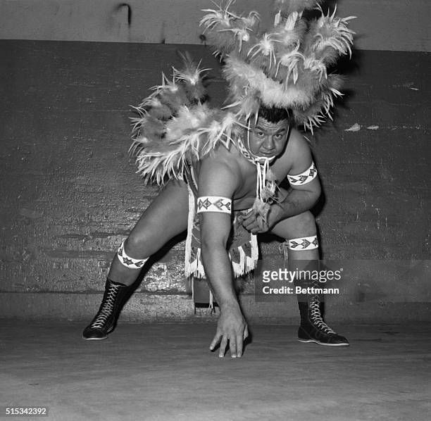 Decked out in Indian feathers, Wahoo McDaniel, New York Jets' middle linebacker, warms up with a football stance before making his wrestling debut at...