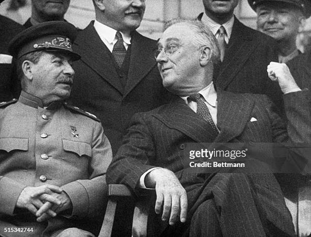 While posing for photographers President Roosevelt and Premier Stalin of Russia had a high old time, even conversing, with the use of ?thumb...
