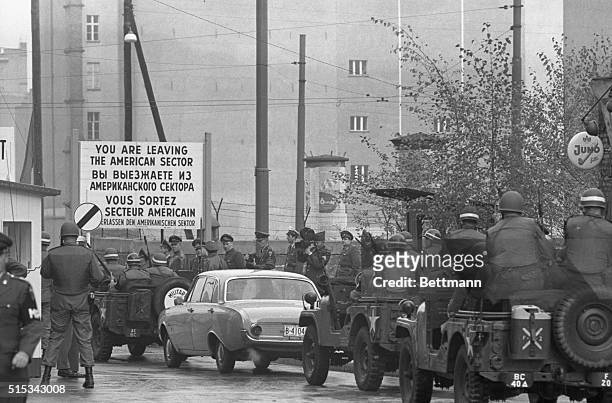 Three jeeps with armed U.S. Military police escort an American automobile into East Berlin at the Friedrich-Strasse checkpoint October 25th. The car,...