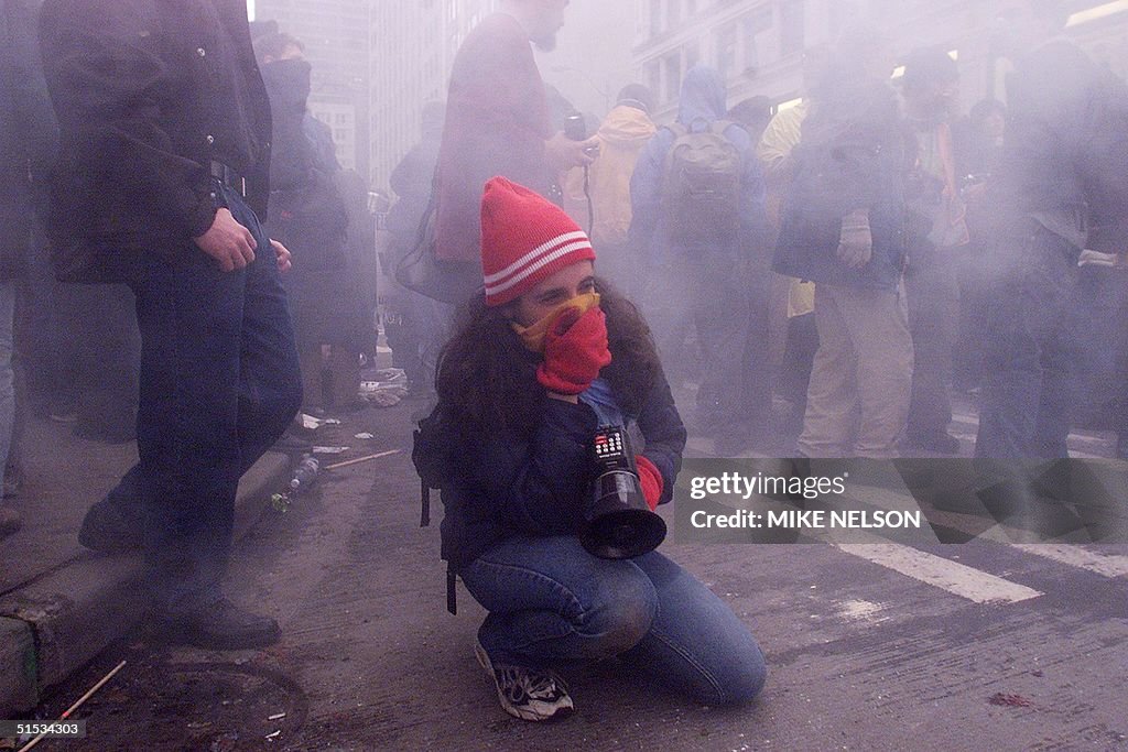 A demonstrator covers her mouth with a scarf to pr