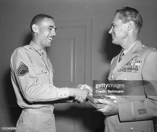 Gen. Hoyt S. Vandenberg, USAF Chief of Staff inspects the medals won by Sgt. Malvin G. Whitfield outstanding performer during the recent Olympic...