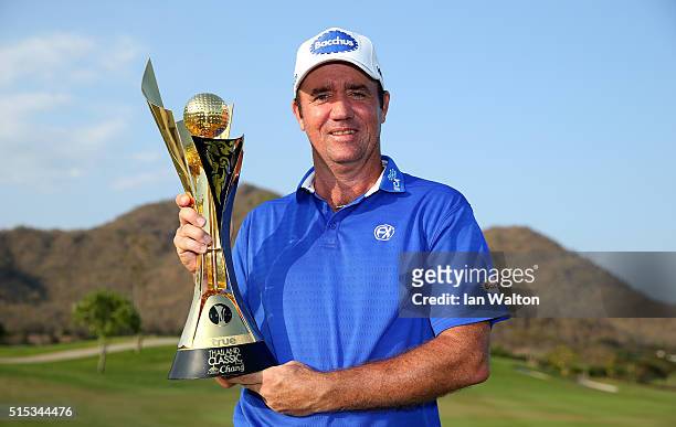 Scott Hend of Australia celebrates with the trophy after claiming victory during the final round on day four of the Thailand Classic at Black...