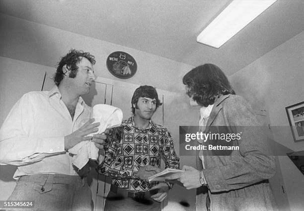 Robin Herman, New York Times sports writer, interviews Chicago Black Hawks' goalie Tony Esposito, and center Ivan Boldirev in Coach Billy Reay's...