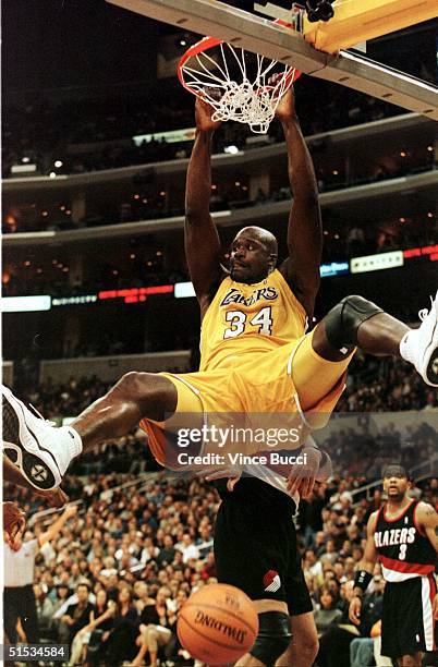 Shaquille O'Neal of the Los Angeles Lakers hangs on to the rim after slam dunking the ball during game against the Portland TrialBlazers 03 December...