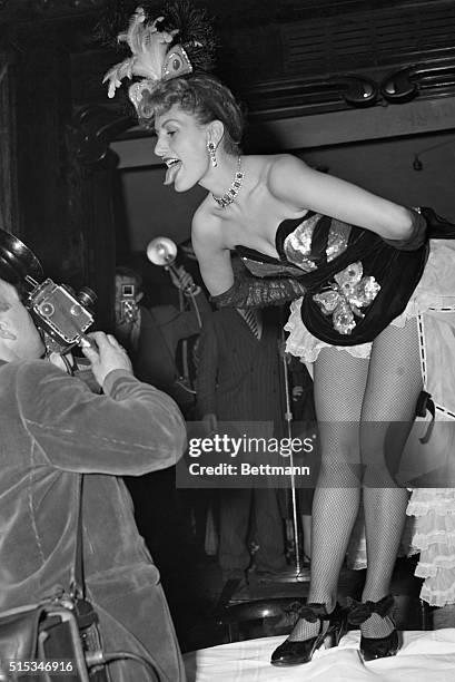 Arms akimbo, beautiful Can Can dancer Gaby Bruyere playfully sticks out her tongue at a cameraman during a party at Maxim's, famed Parisian...