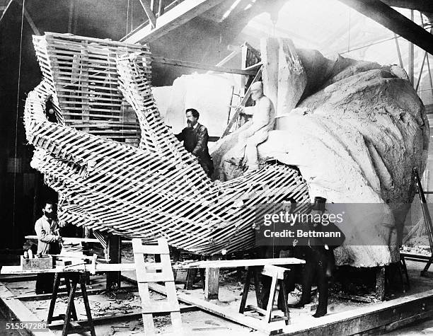 Frederic-Auguste Bartholdi, the creator of the Statue of Liberty, explains the inner construction of the Hand section of the statue to a visitor.