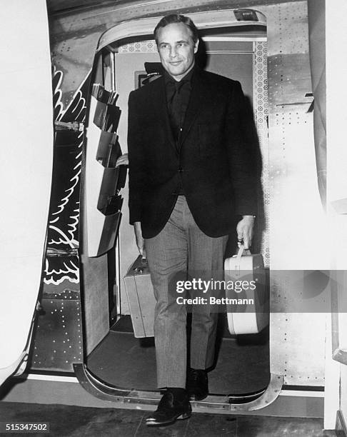 Marlon Brando waves his greetings to New York upon arriving at Idlewild Airport from Hollywood. America's top box office actor is in town for several...