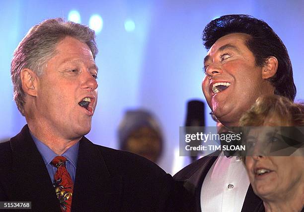 President Bill Clinton sings Christmas carols with Las Vegas performer Wayne Newton at the Pageant of Peace show on the ellipse 08 December, 1999 in...