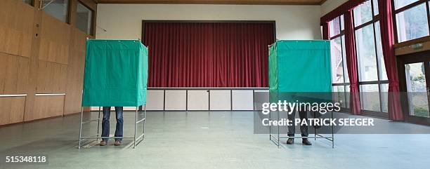 People stand at election booths in Kirnbach, southern Germany during regional state elections in Baden-Wuerttemberg, on March 13, 2016. More than 12...