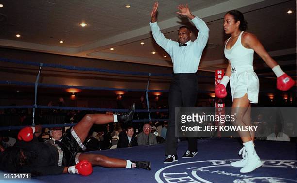Laila Ali watches her opponent Nicolyn Armstrong fall to the mat as the referee stops their fight in the second round at Cobo Hall in Detroit on 10...