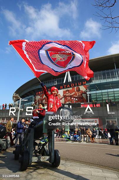 An Arsenal fan waves a flag outside the stadium prior to the Emirates FA Cup sixth round match between Arsenal and Watford at Emirates Stadium on...