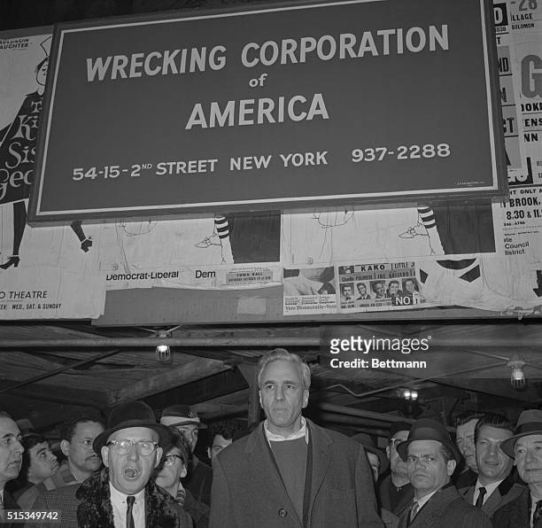 Millionaire arts patron, Huntington Hartford, leader in the effort to save teh 84-year-old Metropolitan Opera House, stands glumly beneath the sign...