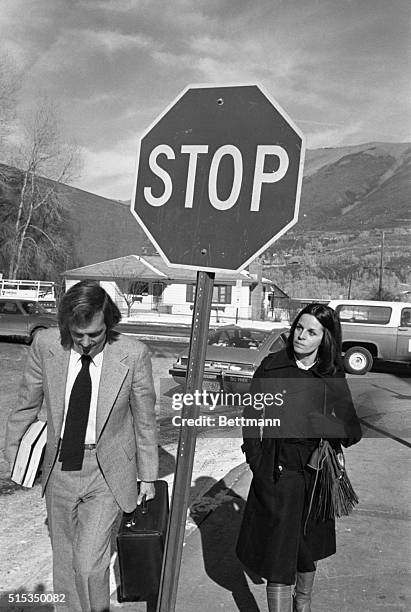 Attorney Ron Austin ducks around a "stop" sign as he walks to lunch with singer actress Claudine Longet. Miss Longet is charged with felony...