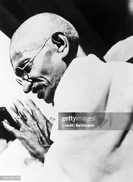 Mahatma Gandhi, leader of the Indian nationalists, bows in acknowledgement of the cheers of his followers outside his residence in Bombay, following...