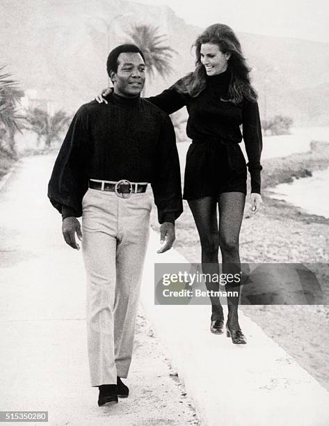 Almeria, Spain-To be on a reasonably equal level with the giant of a man beside her, Raquel walks above him, as she and Jim Brown stroll along a...