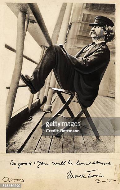 Writer Mark Twain relaxes on a ship deck with his feet on the railings.
