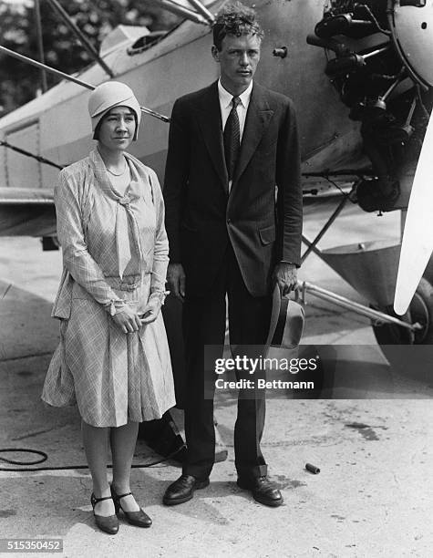 Famed pilot Charles Lindbergh and his wife Anne Morrow Lindbergh pose in front of a biplane shortly after their marriage.