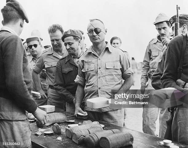 Tel Aviv, Israel- Brigadier General Moshe Dayan, the Israel Army Chief of Staff , is shown receiving bread on the noon "chow line" along with other...