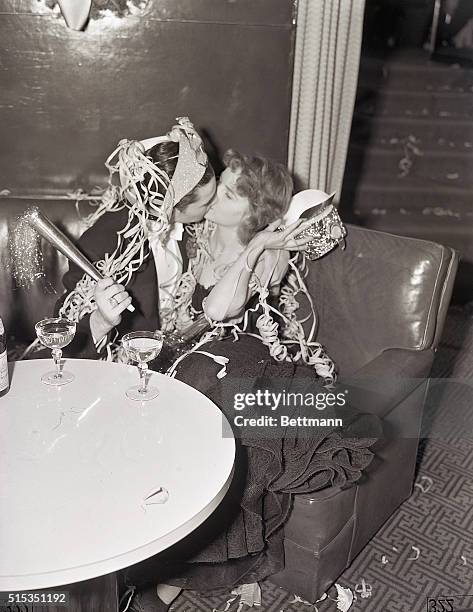 Captain Sol Gerson and his companion, Miss Gertrude Holtorf, share a kiss to welcome in the New Year at the Rainbow Room in New York City.